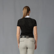 Back view of a model wearing the Equinavia Sara Womens Perforated Short Sleeved Show Shirt in black and white on a gray background