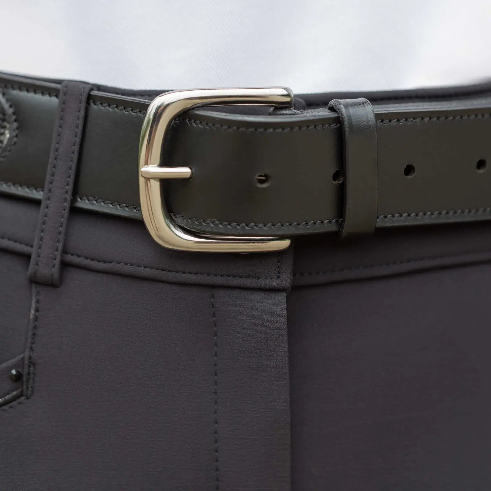 Close-up view of the buckle on the black Equinavia Erika Crystal Bit Belt over black breeches