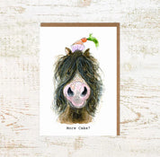 View of the More Cake Pony Pony Nut Greeting Card on a white washed wood background