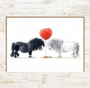 View of the One Heart Pony Nut Greeting Card on a white washed wood background