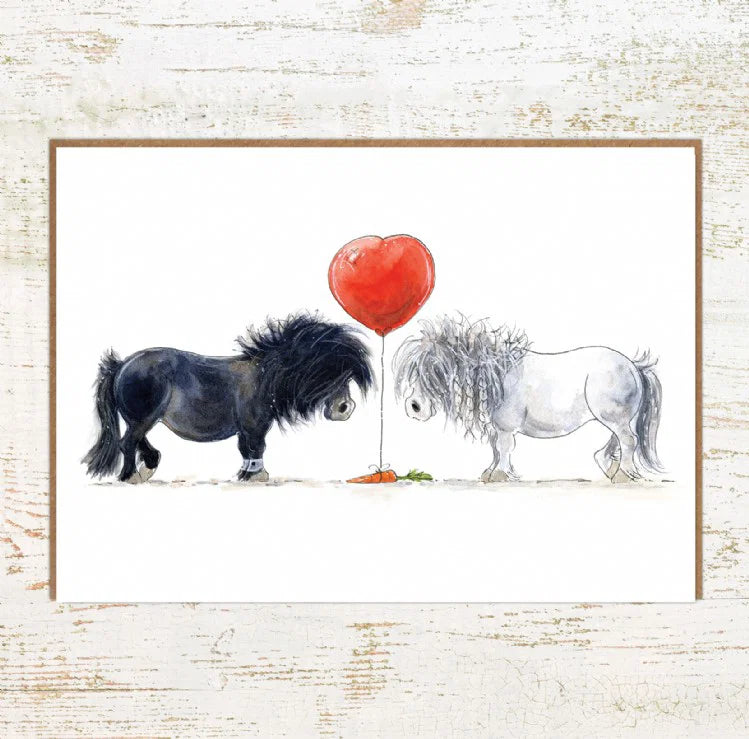 View of the One Heart Pony Nut Greeting Card on a white washed wood background