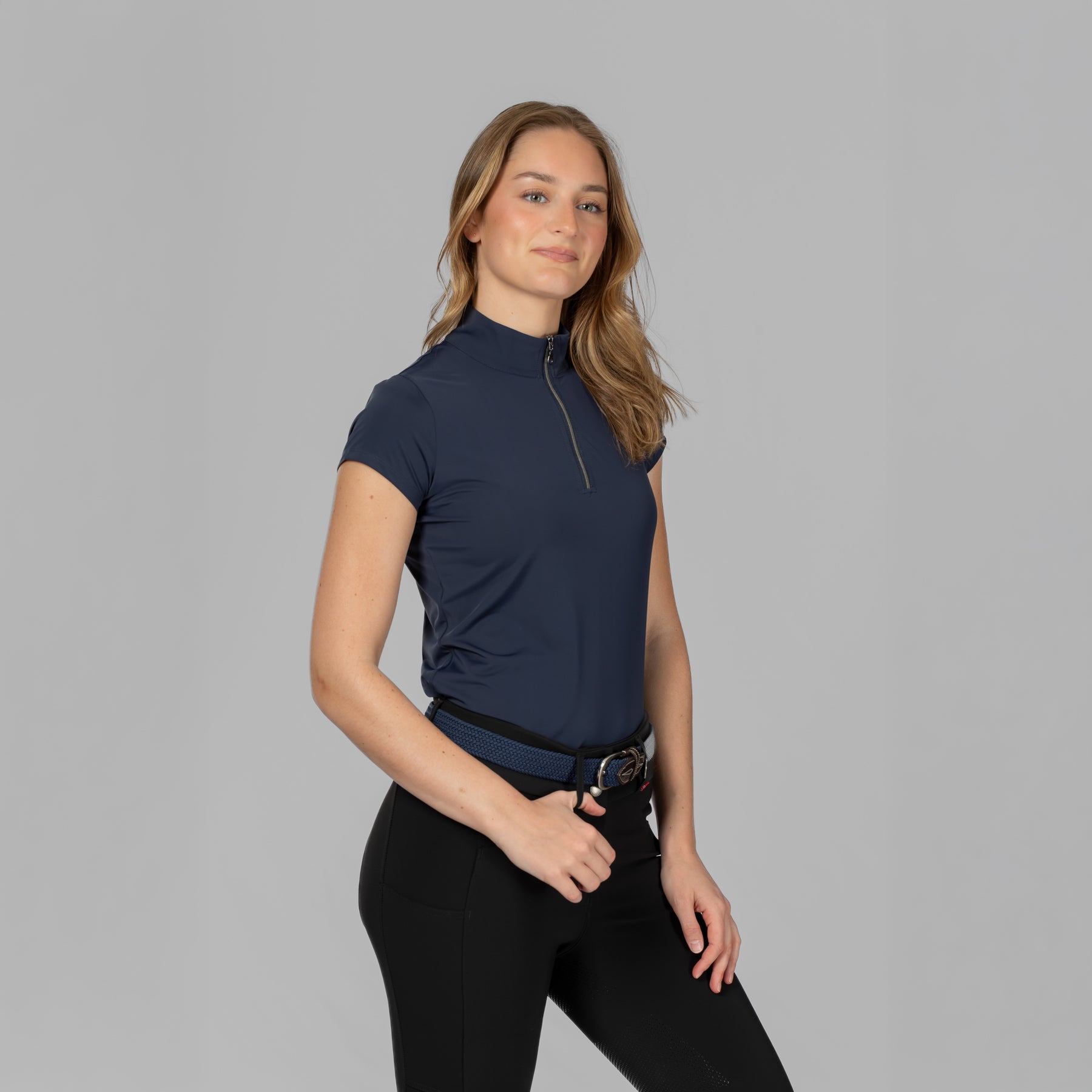 Angled front view of a female model wearing the B Vertigo Aubrie Cooling Training Shirt on a plain background