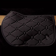 Side view of the black swarovski embroidered Samshield Spineshield Jump Pad hanging over a wood panel