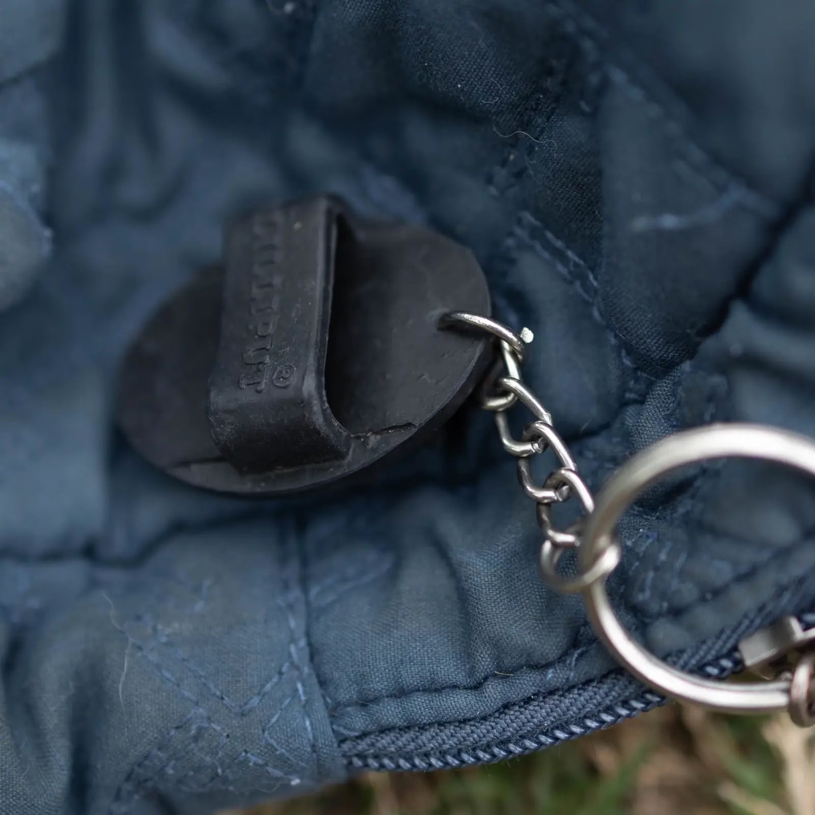 View of the black Horze Brush Key Chain on a blue zipper