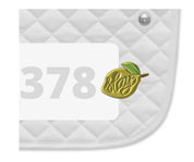 Side view of a white pad with numbers 378 and a Slay Lemon Dubois Cheval Number Pin Charm on a white background