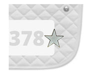 Side view of a white pad with numbers 378 and a Shining Star Dubois Cheval Number Pin Charm on a white background