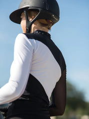 Angled back view of a female model wearing the black and white Criniere Sophie Stride & Conquer Schooling Shirt