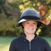 Front view of a female model wearing the black EquiVisor VUE Sun Visor over a black helmet while standing outside