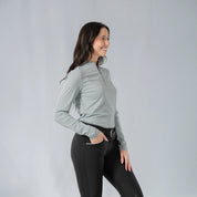 Angled front view of a model wearing the Equinavia Kari Womens Long Sleeve Sun Shirt with NordicAir Tech in gray on a gray background