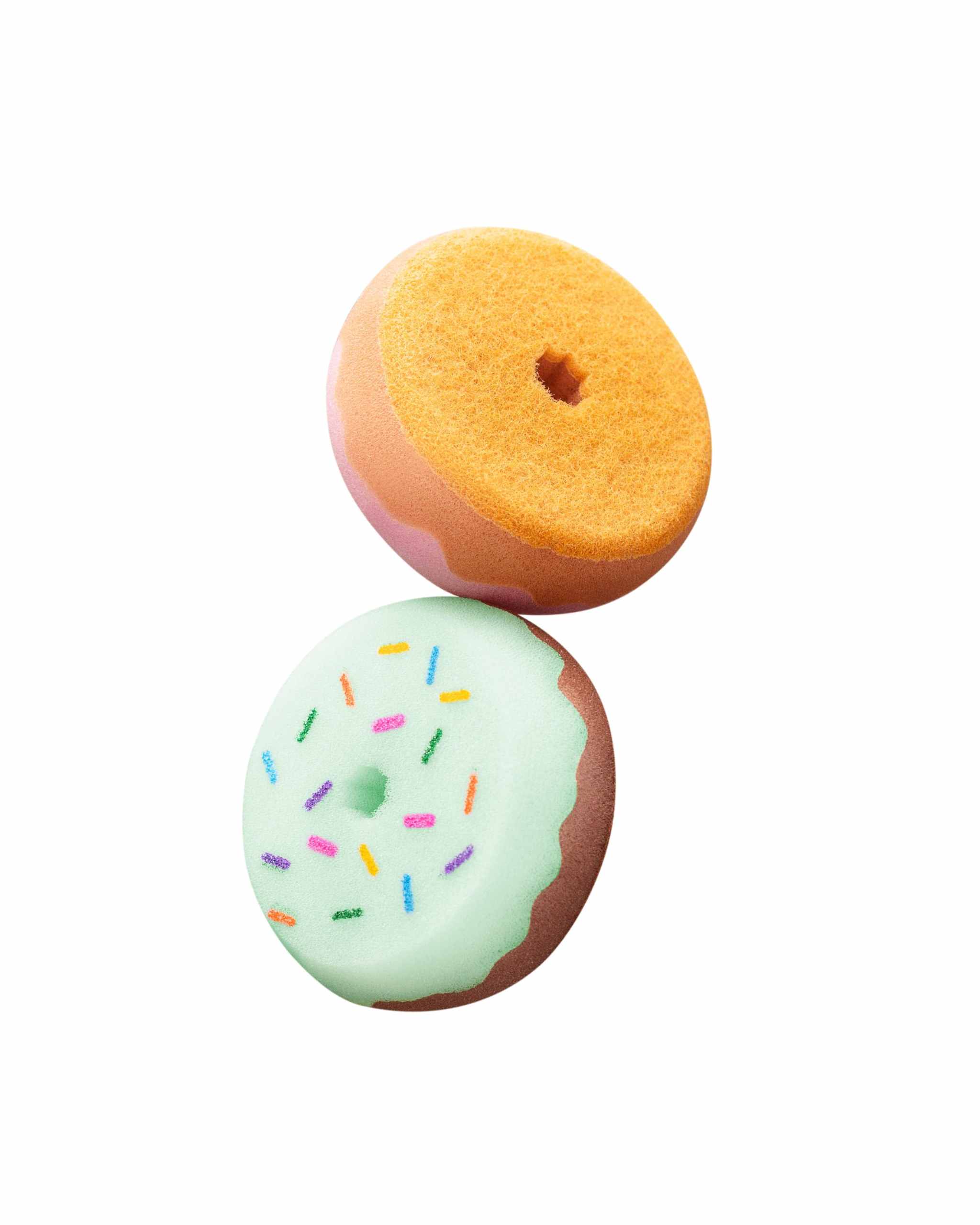 View of 2 Dreamers and Schemers Donut Tack Cleaning Sponges stacked on top of each other on their sides on a white background
