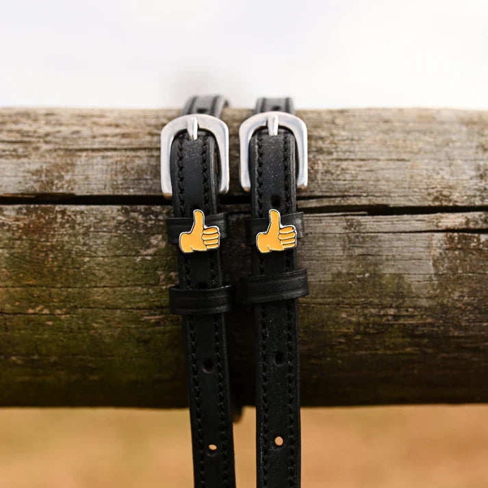 Front view of the buckled Thumbs Up Mane Jane Spur Straps on a wood rail