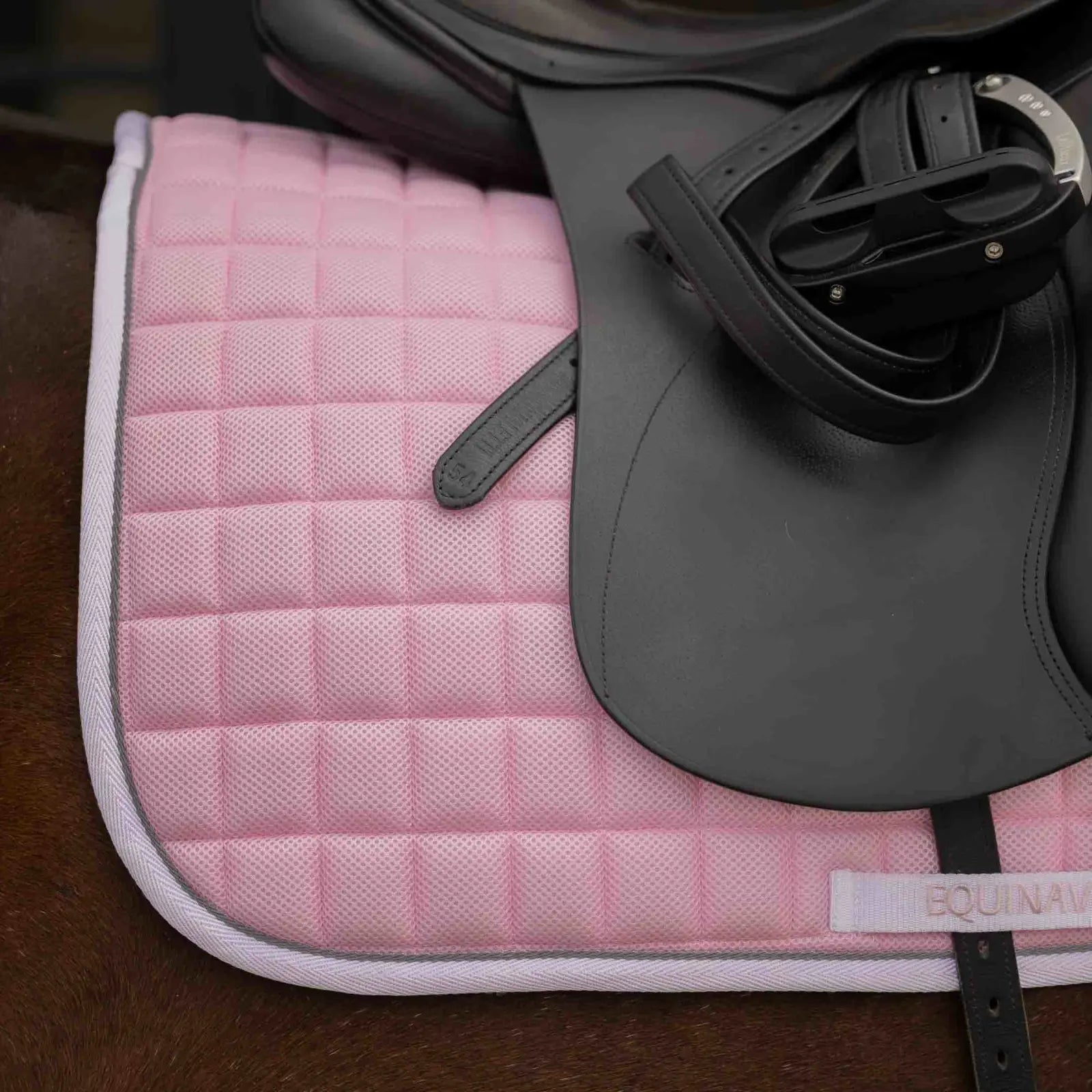 Close-up side view of a bay horse wearing the pink Equinavia Svalbard Dressage Saddle Pad with NordicAir Tech under a saddle