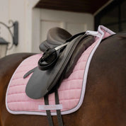 Angled front view of a bay horse wearing the pink Equinavia Svalbard Dressage Saddle Pad with NordicAir Tech under a saddle