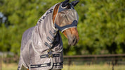 Angled front view of a horse wearing the navy Lemieux ArmourShield Pro Half Fly Mask outside
