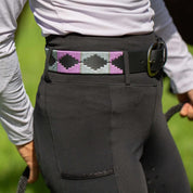 Close up view of the purple and gray, black-leather Equinavia Siri Polo Belt on black breeches