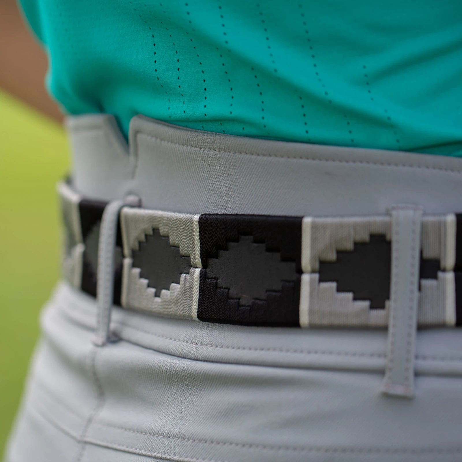 Close-up view of the gray and black, black-leather Equinavia Siri Polo Belt on gray breeches