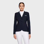 Front view of a female model wearing the navy Samshield Victorine Show Coat on a white background
