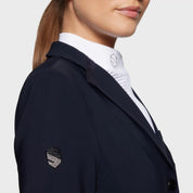 Close-up side view of a female model wearing the navy Samshield Victorine Show Coat on a white background