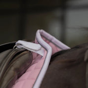 Close-up view of the anatomic withers and D-ring attachment loops on the pink Equinavia Svalbard Dressage Saddle Pad with NordicAir Tech under a saddle