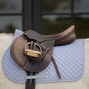 Side view of the gray Equinavia Harstad All Purpose Pad under a brown saddle and on a gray horse