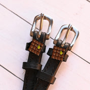 Close-up view of the Waffle Mane Jane Spur Straps on a white wood plank background