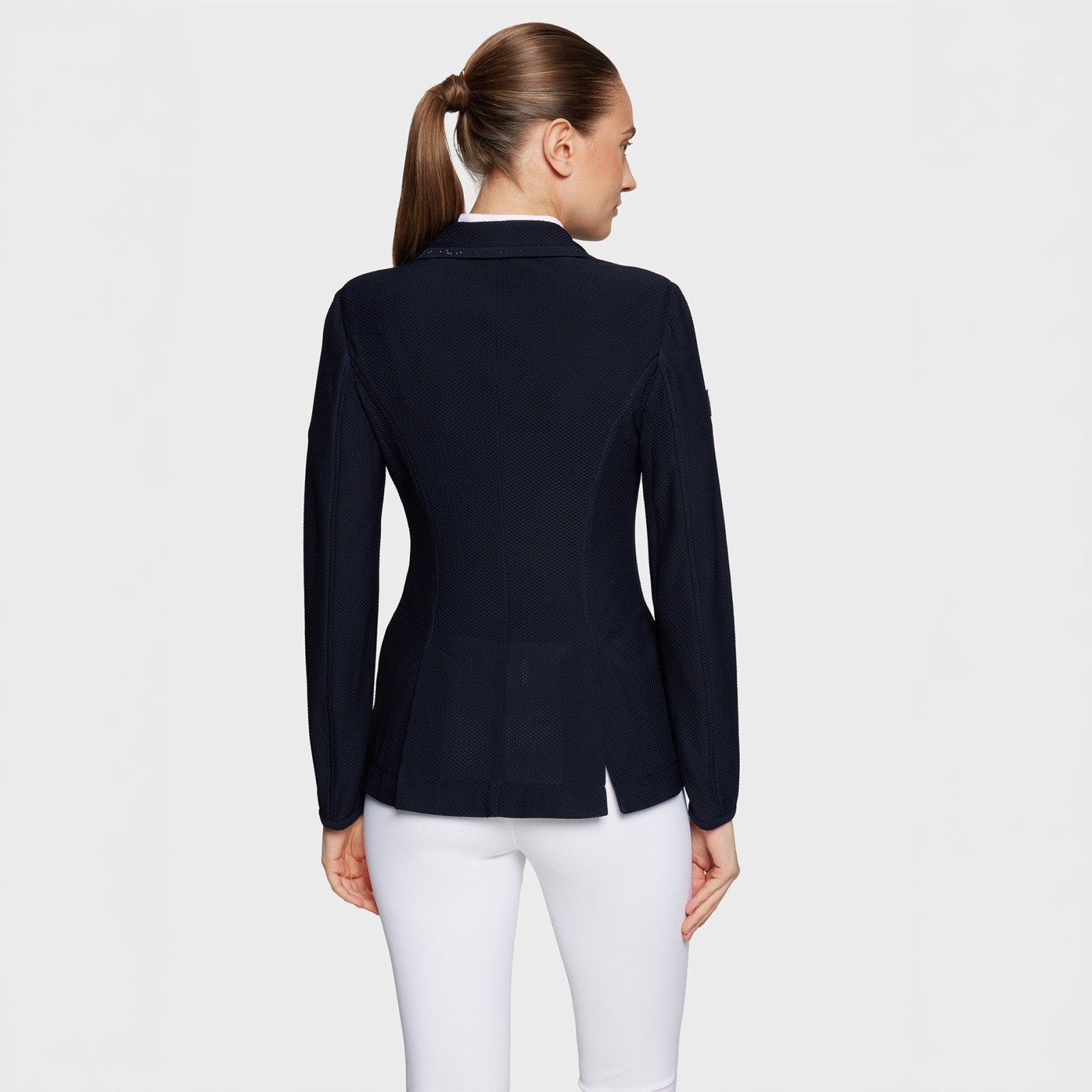 Back view of a female model wearing the Navy Samshield Wellington Crystal Show Coat on a plain background
