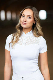 Front view of a female model wearing the white Equestrian Stockholm Crystal Champion Competition Top