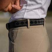 View of a black leather Equinavia Estelle Hand Beaded Belt with black and silver beading on a tan pair of breeches