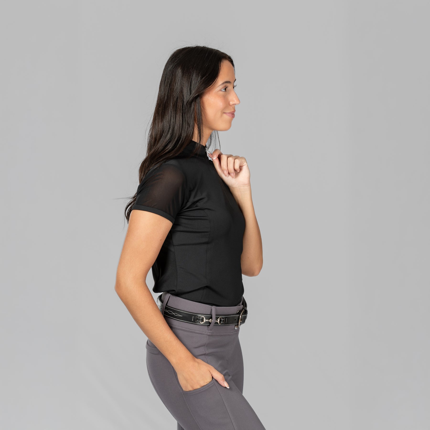 Side view of a female model wearing the Black Horze Mina Mesh Short Sleeve Training Shirt on a plain background