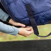 Close-up view of a woman unzipping the navy Horze Saddle Bag