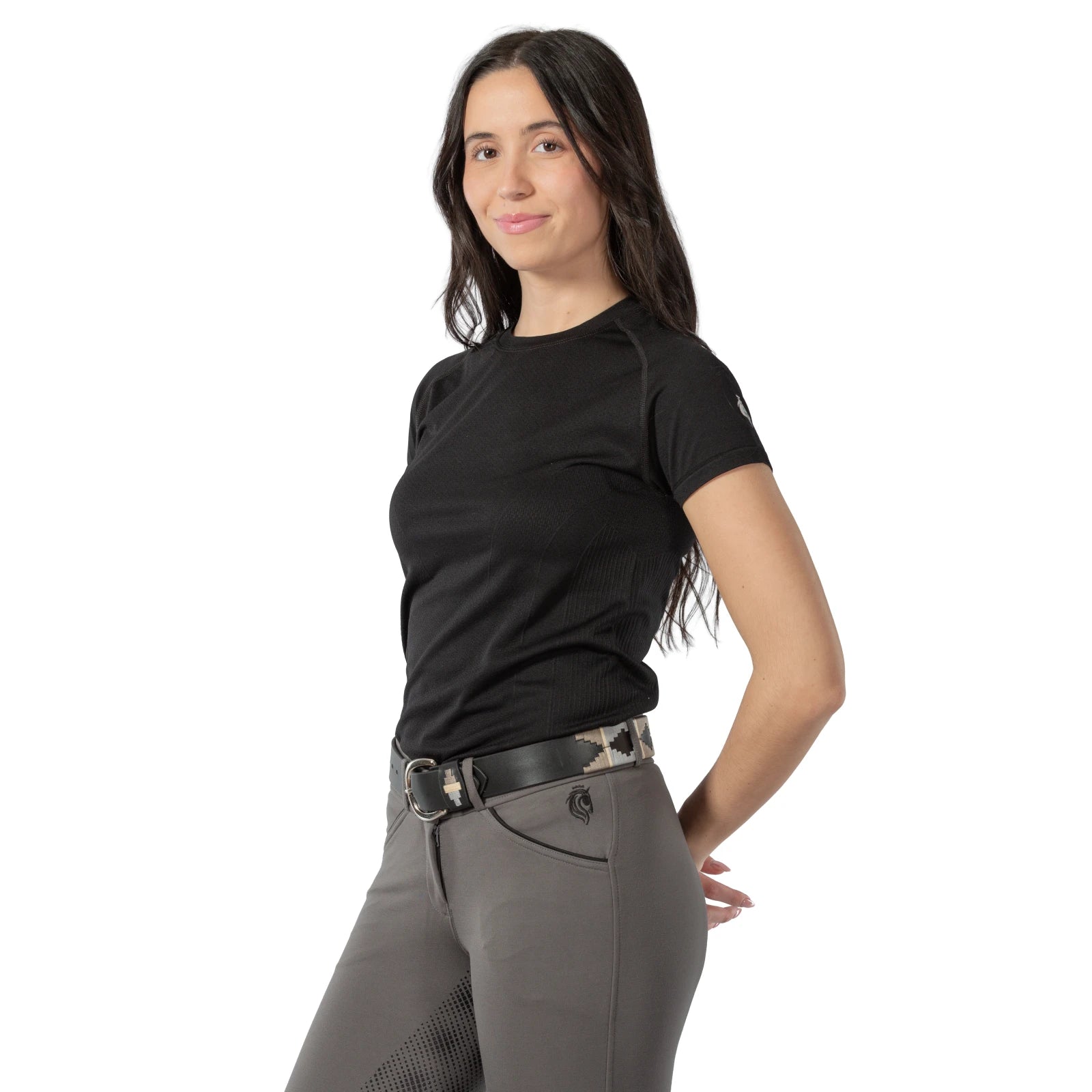 Angled front view of a model wearing a black top, gray breeches, and the beige and gray, black-leather Equinavia Siri Polo Belt on a white background