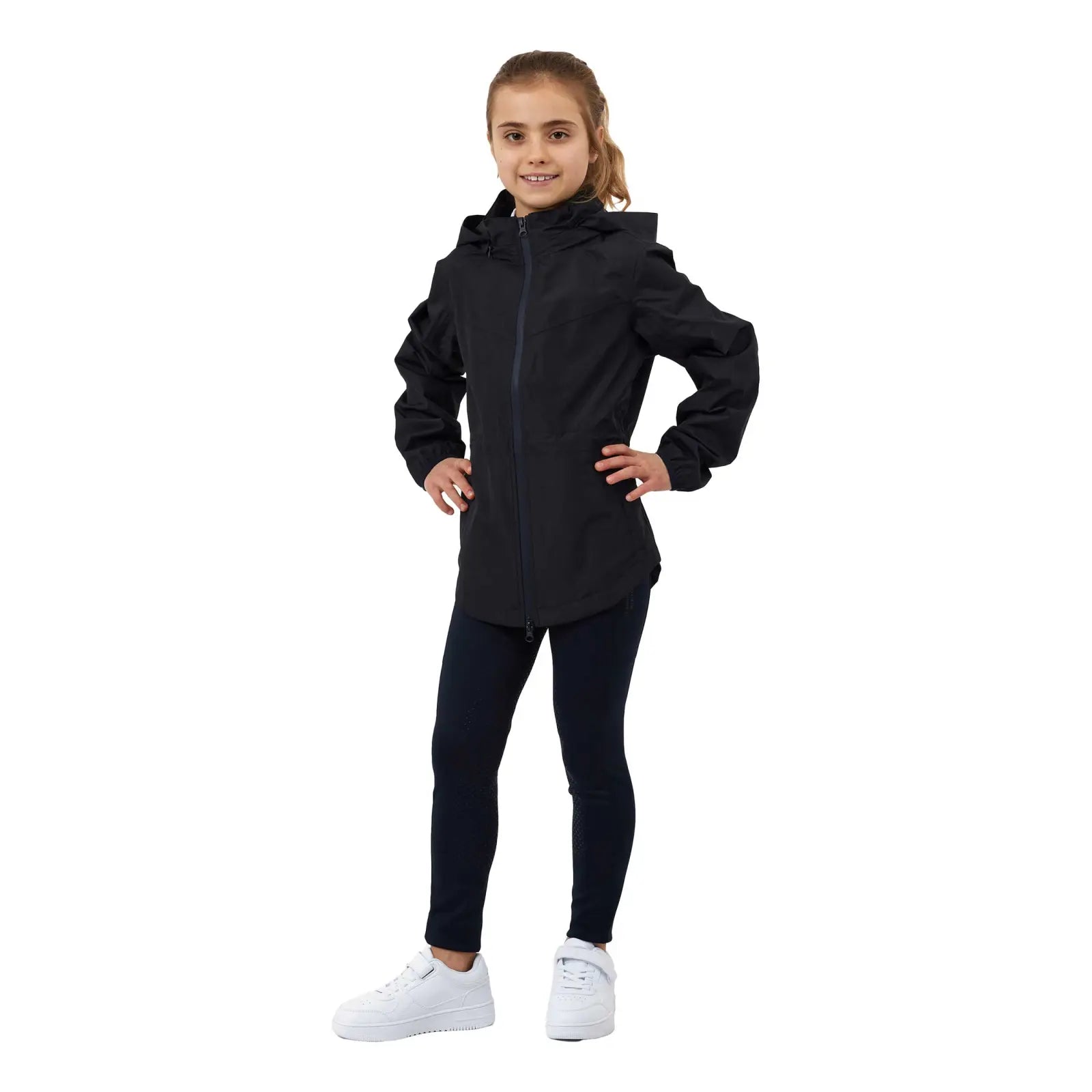 Full body front view of the navy Horze Fiora Kids Lightweight Waterproof Jacket, dark pants, and white shoes on a white background