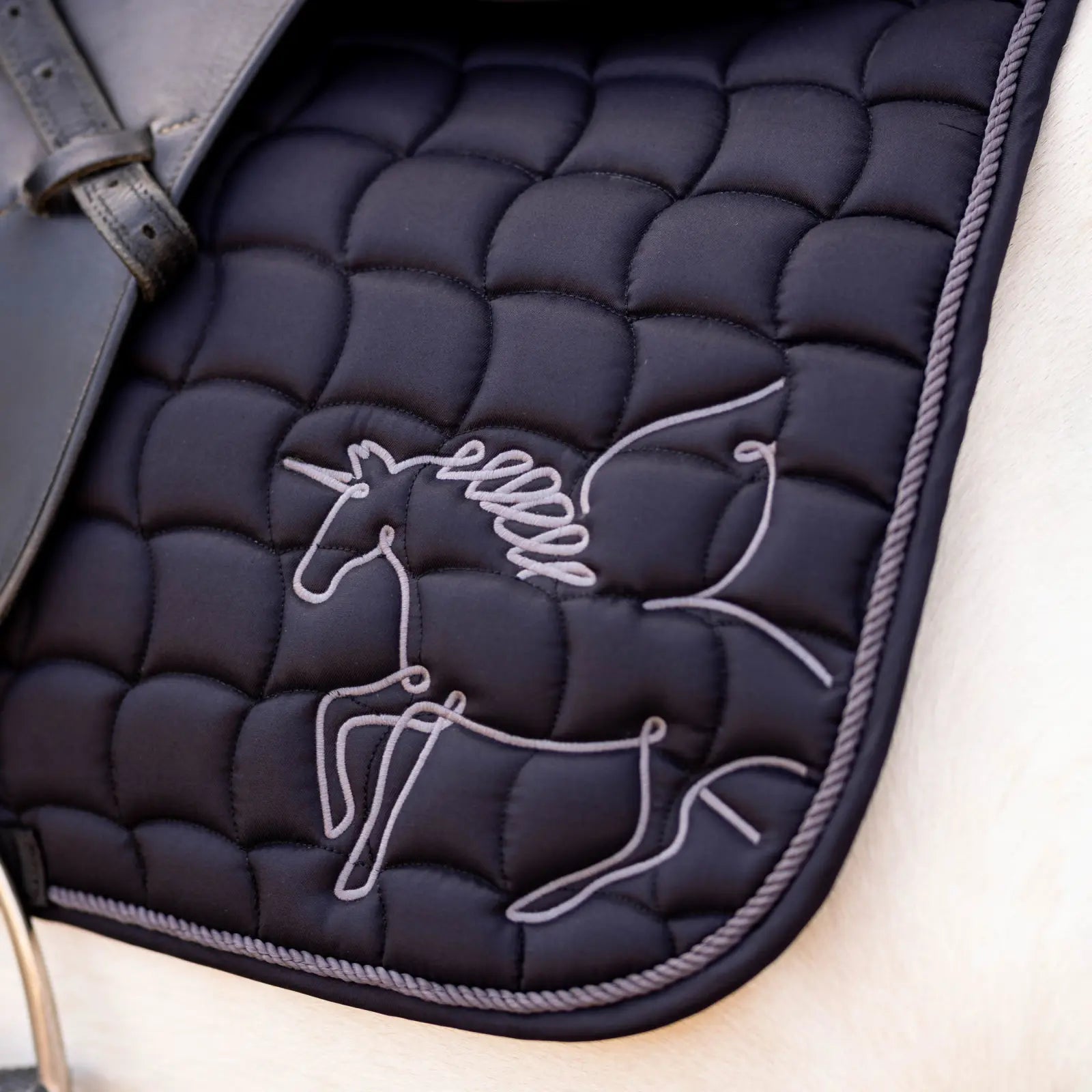 Close-up view of the black Horze Pegasus Pony Saddle Pad on a white horse